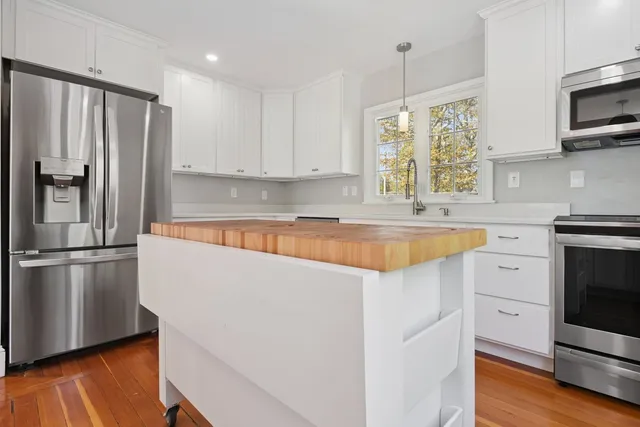 a kitchen with stainless steel appliances a refrigerator sink and microwave