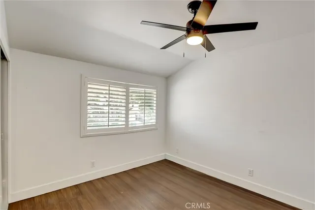 an empty room with a window and a fan