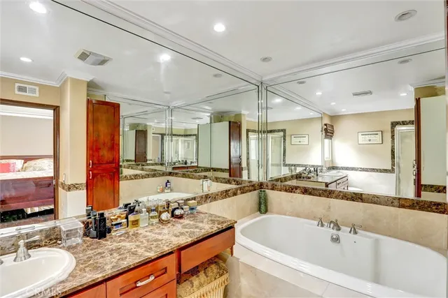 a bathroom with a granite countertop sink mirror and a bathtub