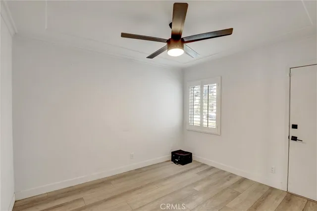 an empty room with a window and a ceiling fan