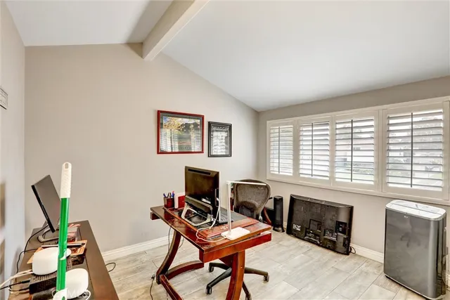 a view of a workspace with furniture and a window