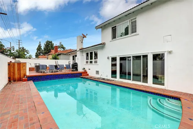 a view of a house with pool and sitting area