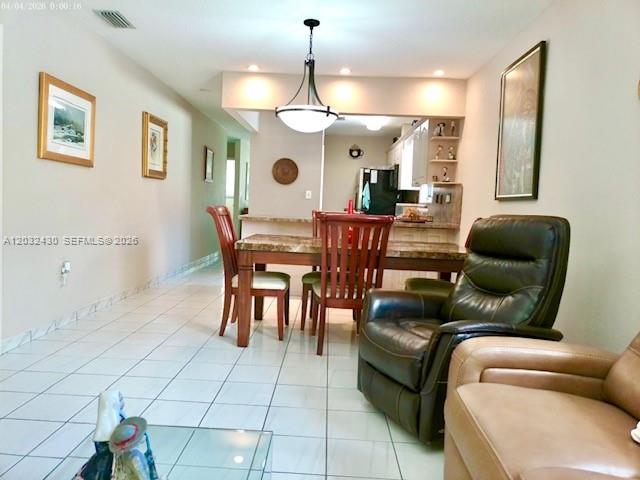 6527 West 22nd Lane Hialeah, FL 33016 - Photo 4 of 18 a living room with furniture a dining table and a chandelier