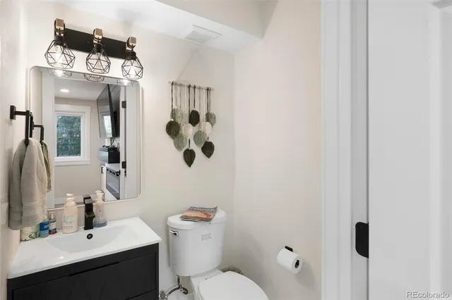a bathroom with a toilet sink and mirror