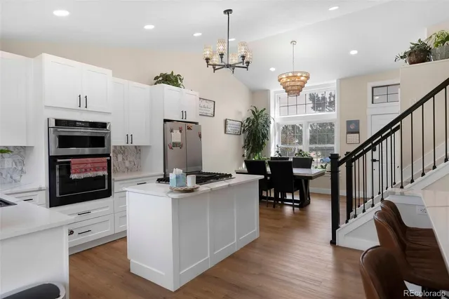 a open kitchen with stainless steel appliances granite countertop a stove and a refrigerator