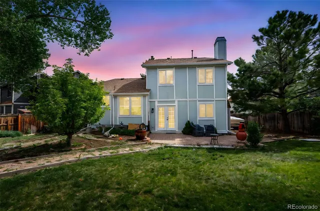 a front view of a house with a yard and tree