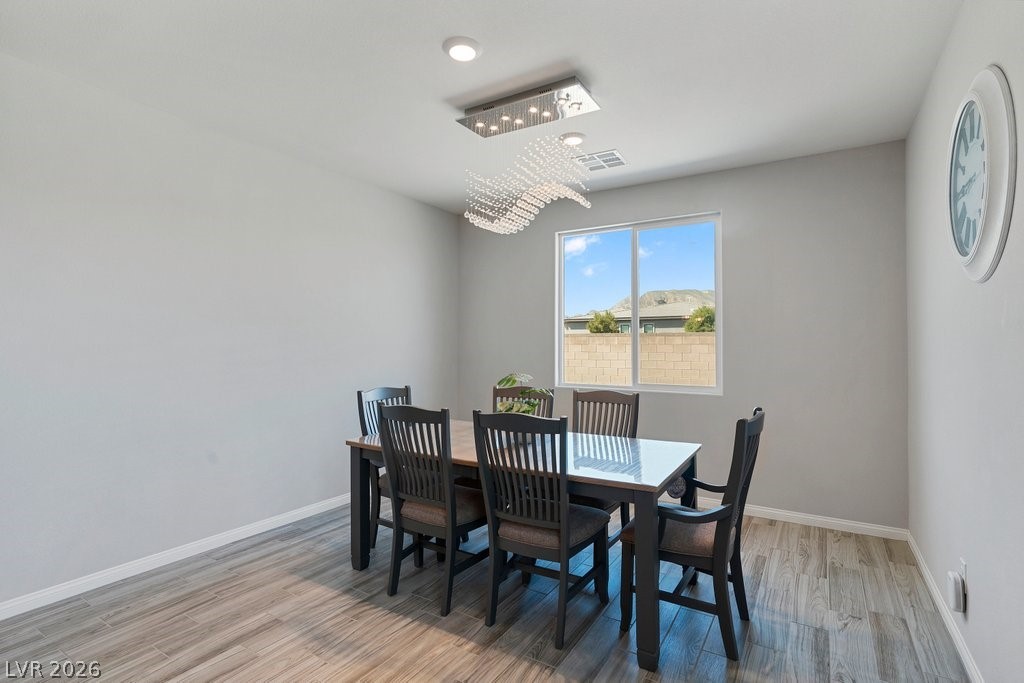 4191 Velvet View Street Las Vegas, NV 89129 - Photo 10 of 44 Dining room with light wood-style floors and suspended lighting