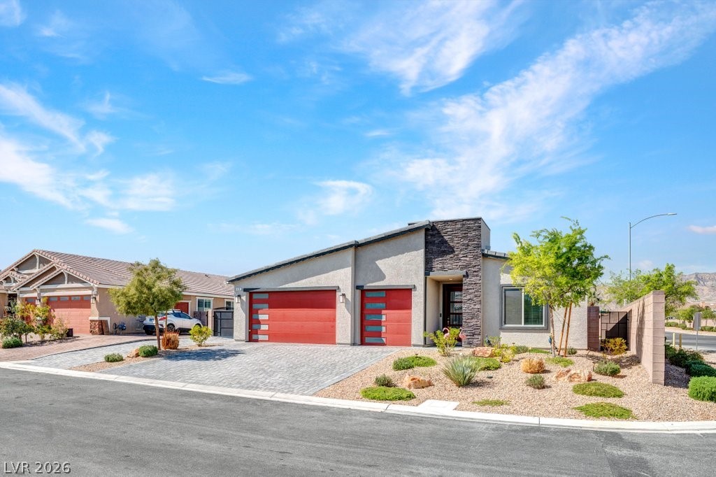 4191 Velvet View Street Las Vegas, NV 89129 - Photo 2 of 44 Contemporary home with a garage, stucco siding, decorative driveway, and stone siding