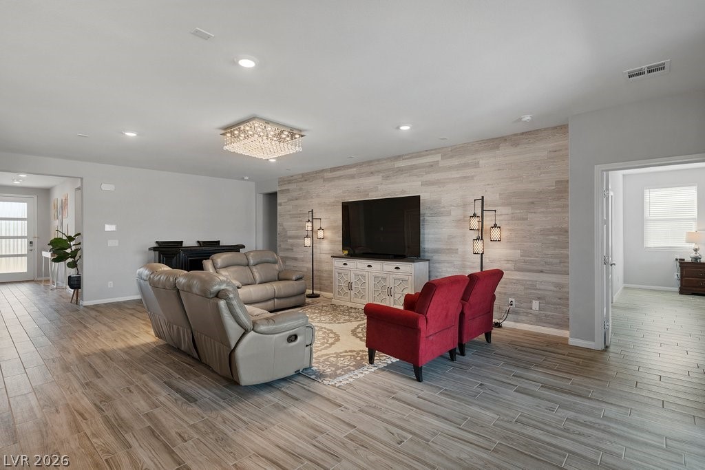 4191 Velvet View Street Las Vegas, NV 89129 - Photo 6 of 44 Living area with healthy amount of natural light, an accent wall, wood finish floors, and recessed lighting