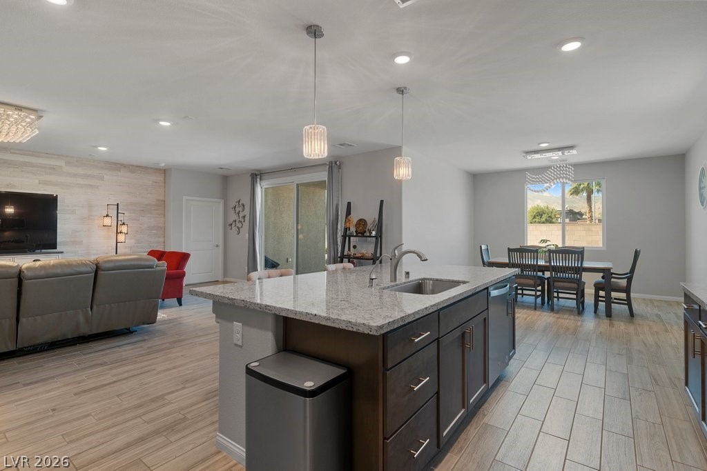 4191 Velvet View Street Las Vegas, NV 89129 - Photo 44 of 44 Kitchen featuring wood finish floors, open floor plan, light stone counters, a kitchen island with sink, and pendant lighting