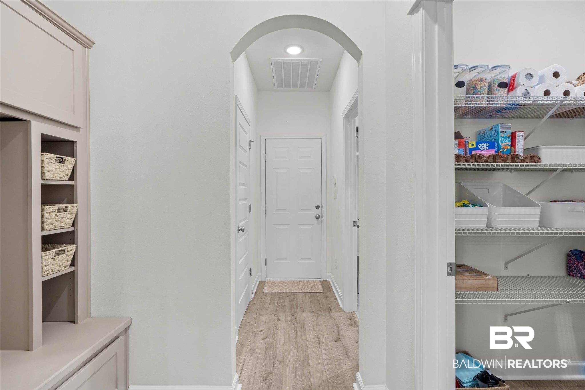 9074 Moses Way Theodore, AL 36582 - Photo 36 of 52 Hallway featuring wood-finish flooring and an arched entryway