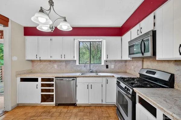 a kitchen with stainless steel appliances granite countertop a sink and dishwasher a stove top oven with wooden floor
