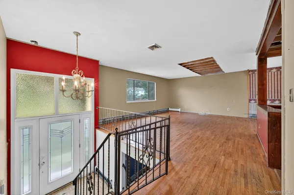 a view of a hallway with wooden floor and stairs