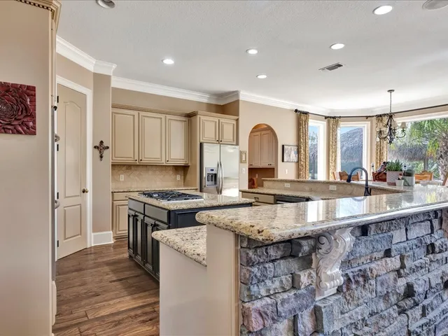 a kitchen with stainless steel appliances granite countertop a stove a sink and a refrigerator