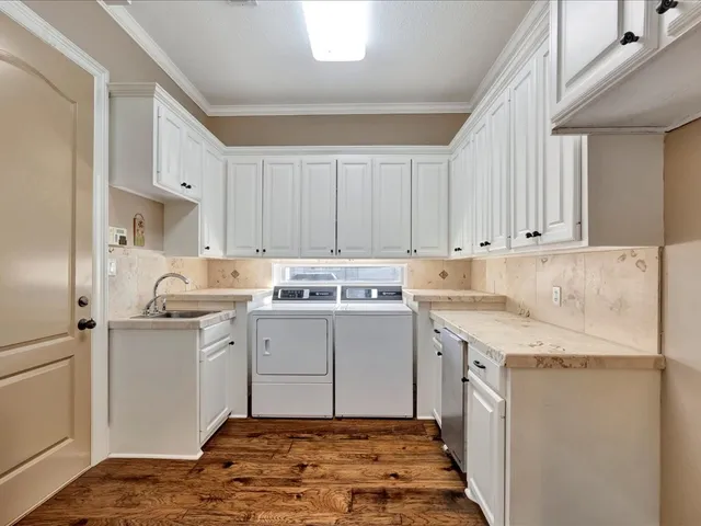 a utility room with cabinets washer and dryer