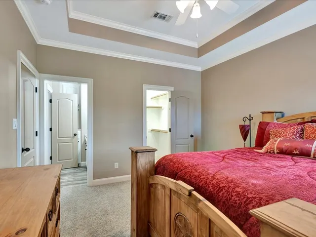 a bedroom with a large bed and a chandelier