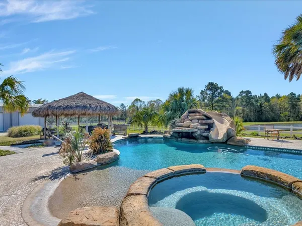 a view of a house with swimming pool and sitting area