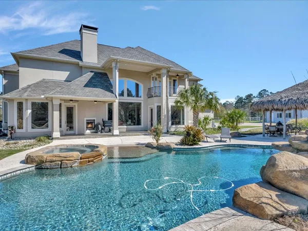 a front view of a house with swimming pool having outdoor seating