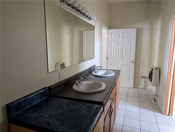 a bathroom with a granite countertop sink and a mirror