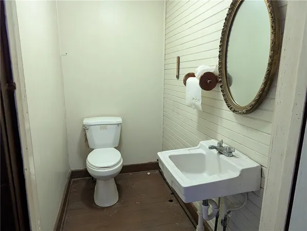 a bathroom with a toilet sink and mirror