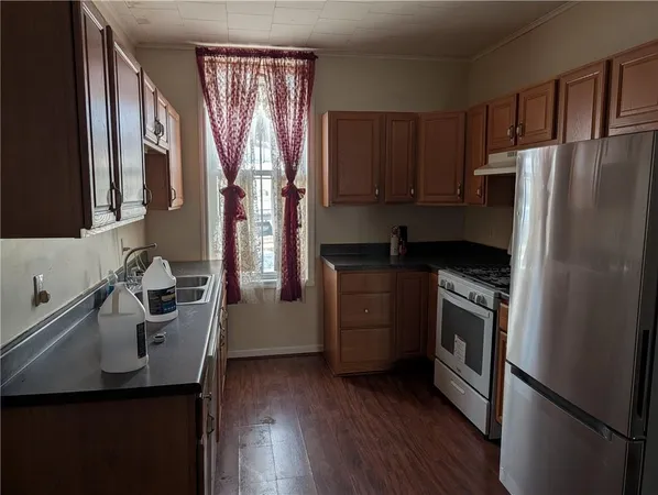 a kitchen with a refrigerator sink and wooden floor
