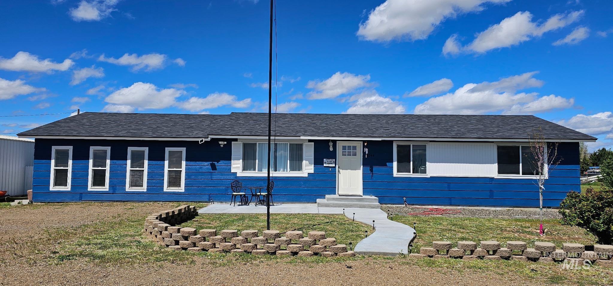 3044 Northeast Reservoir Road Mountain Home, ID 83647 - Photo 1 of 34 Ranch-style exterior featuring blue siding with white accents and a dark shingled roof