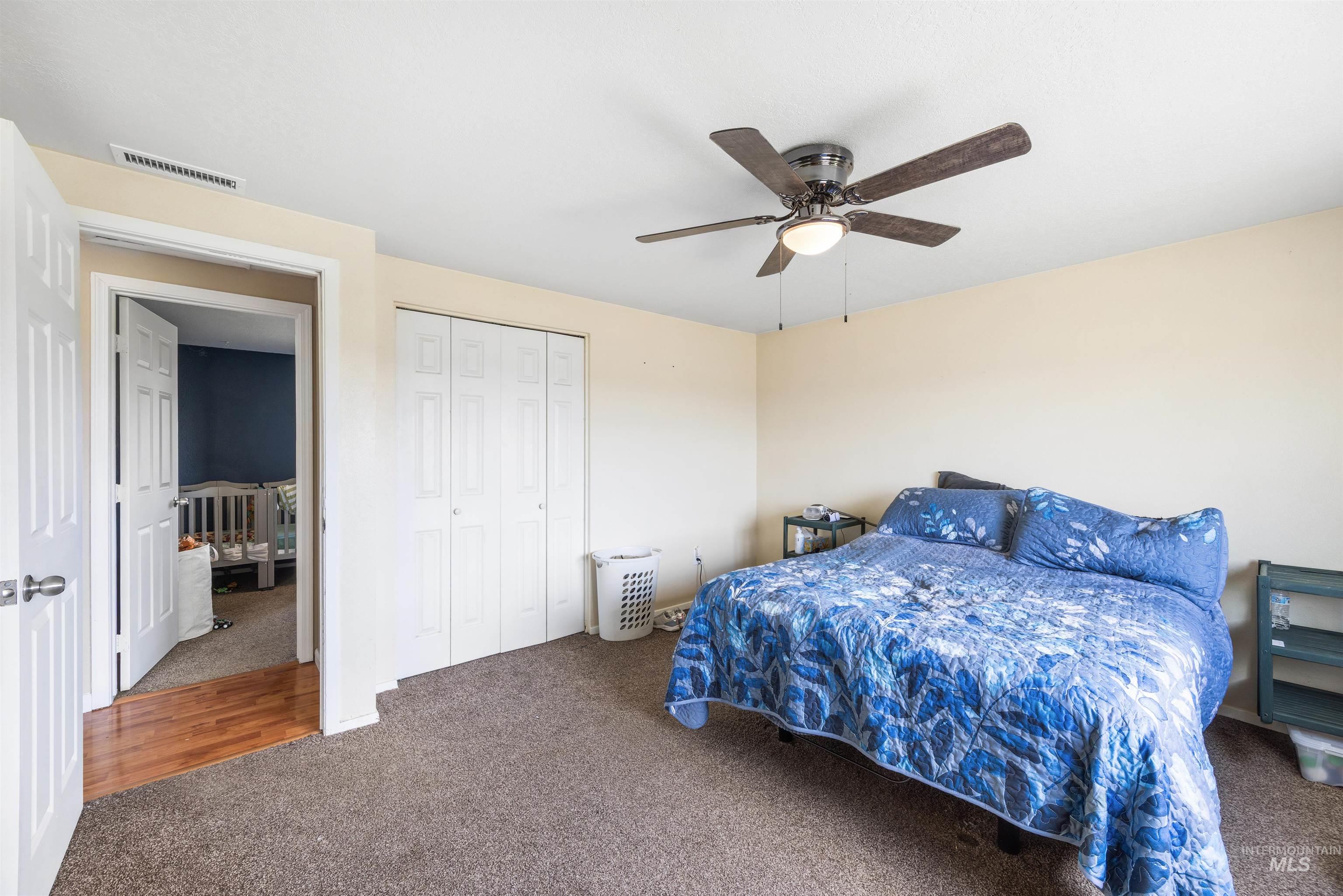 3044 Northeast Reservoir Road Mountain Home, ID 83647 - Photo 17 of 34 Carpeted bedroom with a ceiling fan light fixture and bi-fold closet doors
