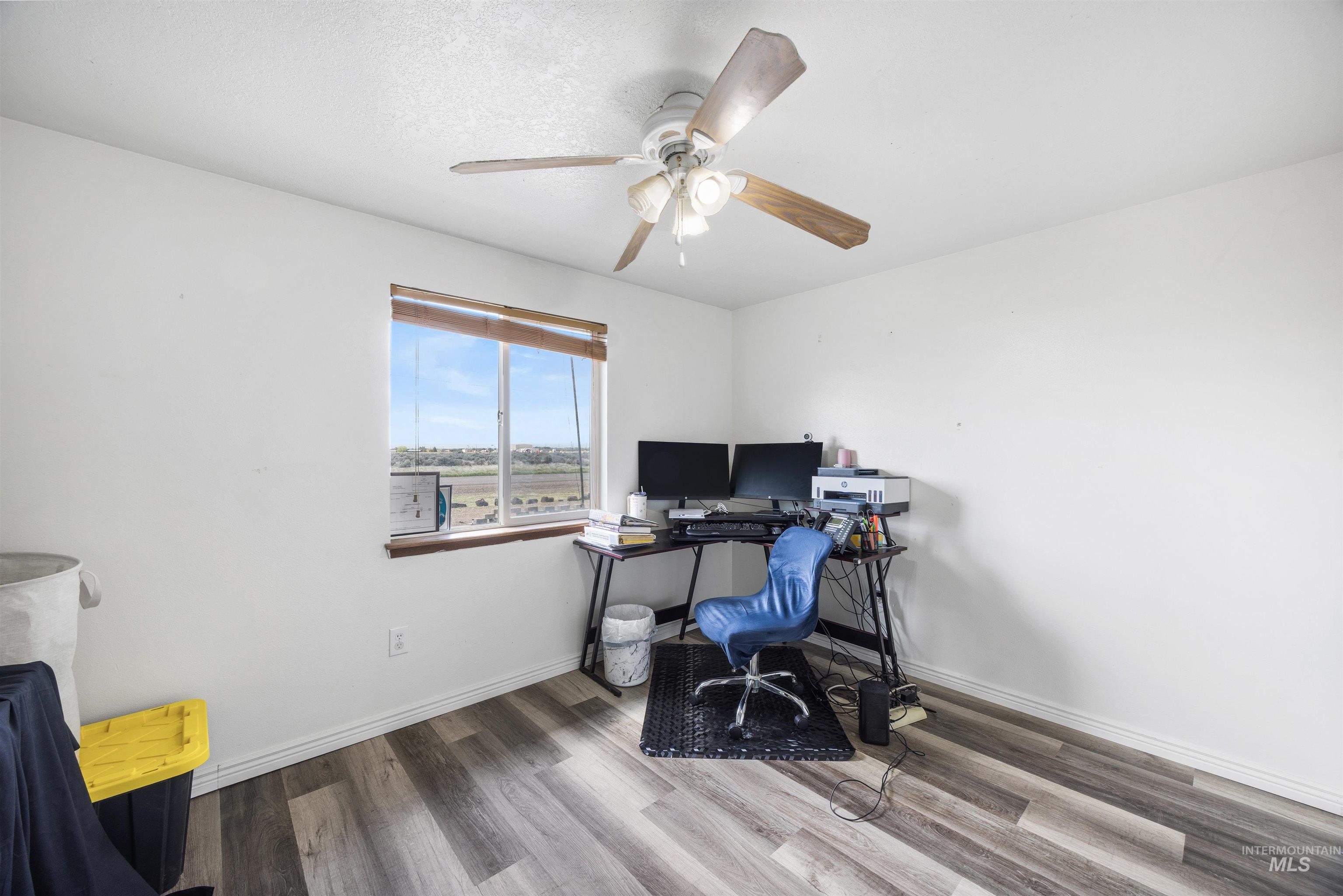 3044 Northeast Reservoir Road Mountain Home, ID 83647 - Photo 22 of 34 Room featuring wood-finish flooring, white baseboards, and a ceiling fan with light fixture