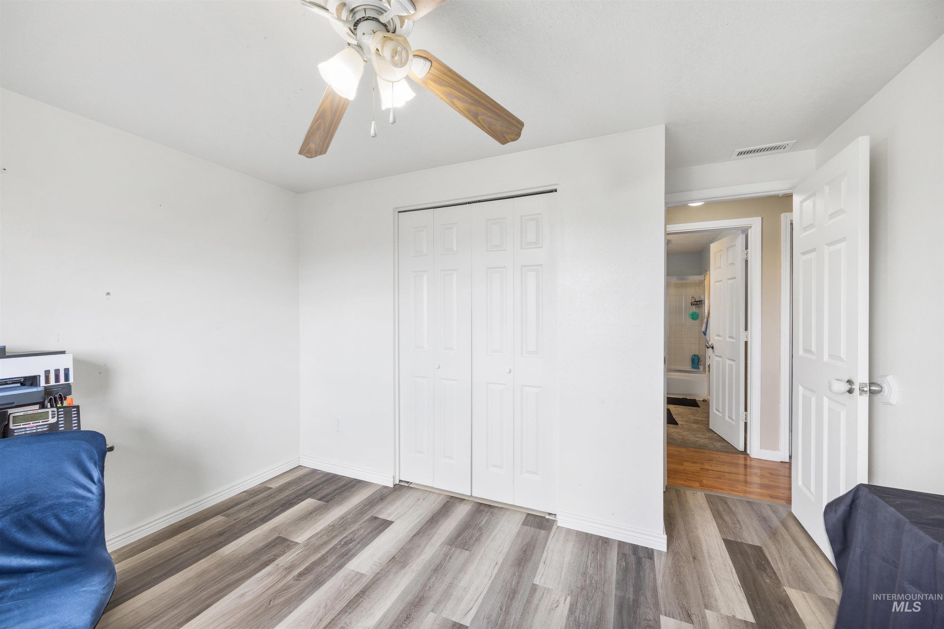 3044 Northeast Reservoir Road Mountain Home, ID 83647 - Photo 23 of 34 Room featuring wood-finish flooring, white baseboards, and a ceiling fan with light fixture