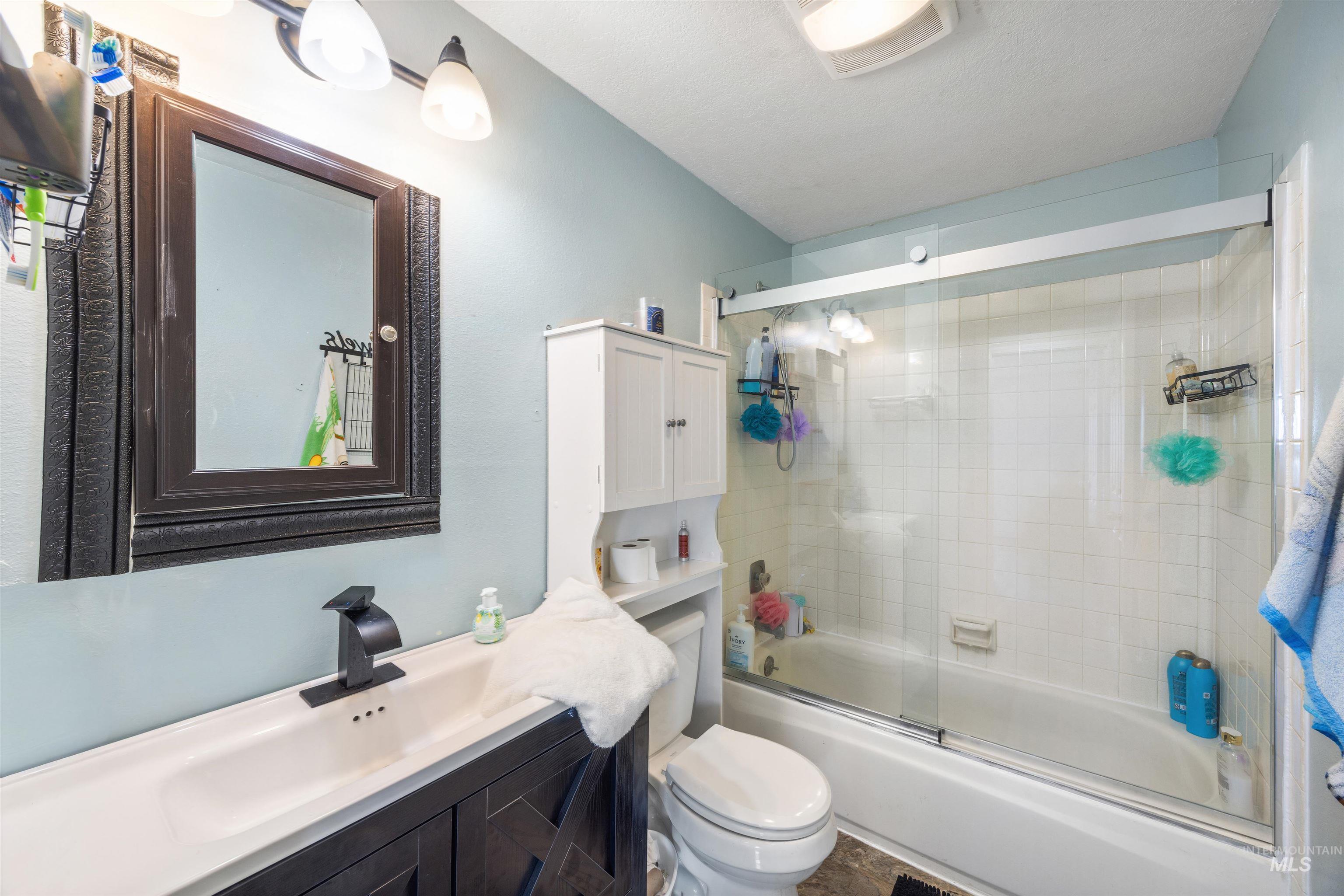 3044 Northeast Reservoir Road Mountain Home, ID 83647 - Photo 25 of 34 Bathroom featuring a dark wood-finish vanity with an integrated white sink and a matte black faucet