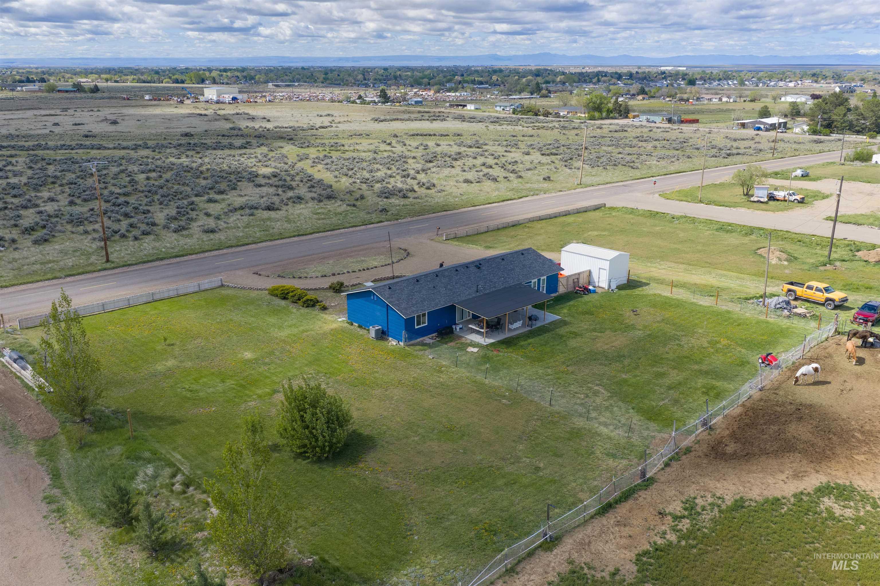 3044 Northeast Reservoir Road Mountain Home, ID 83647 - Photo 32 of 34 Blue single-story residence featuring a dark shingle roof and covered patio