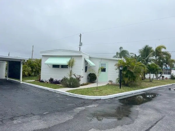 a front view of a house with a yard and potted plants