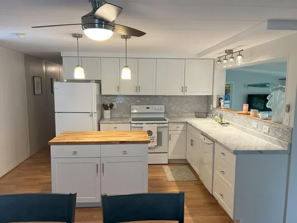 a kitchen with stainless steel appliances granite countertop a sink a stove and a refrigerator