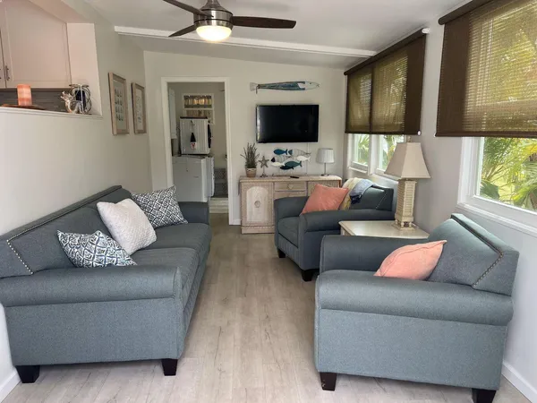 a living room with furniture ceiling fan and a flat screen tv