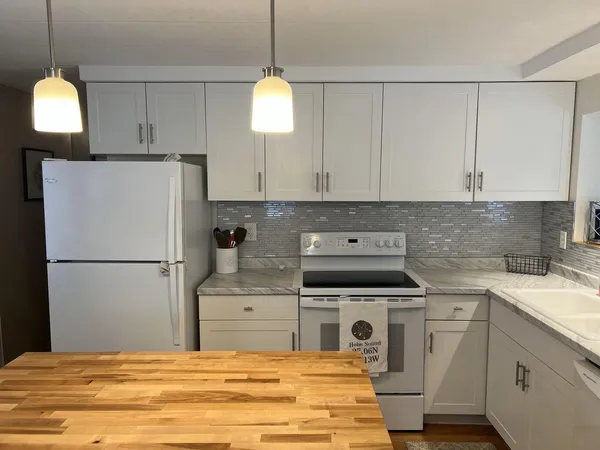 a kitchen with white cabinets and white appliances