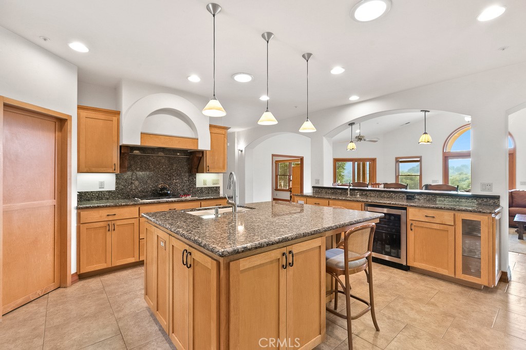 40635 De Luz Road Fallbrook, CA 92028 - Photo 28 of 75 a kitchen with stainless steel appliances granite countertop a stove a sink a oven a dining table and chairs
