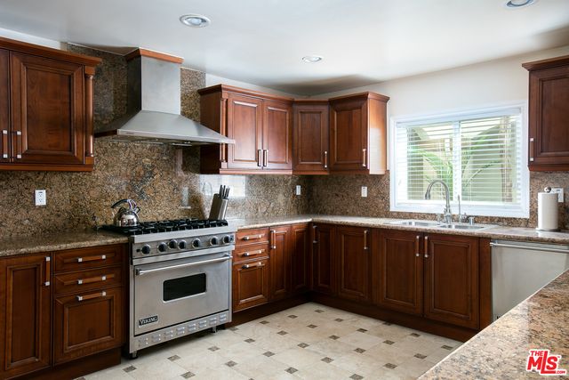a kitchen with a stove sink and cabinets