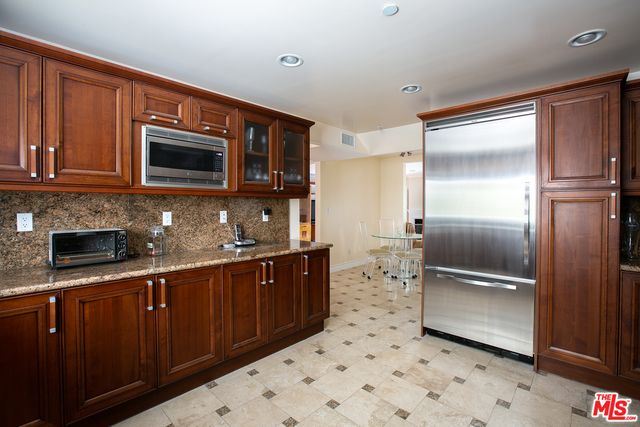 a kitchen with stainless steel appliances granite countertop a refrigerator and a stove top oven