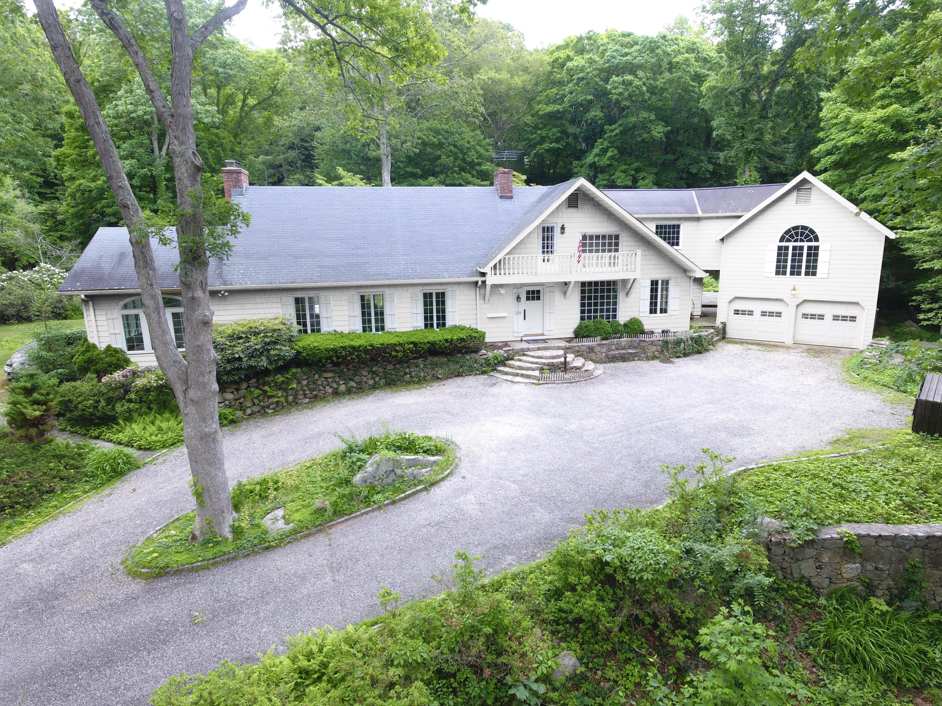 129 Hickok Road New Canaan, CT 06840 - Photo 2 of 32 a front view of a house with a yard and garage