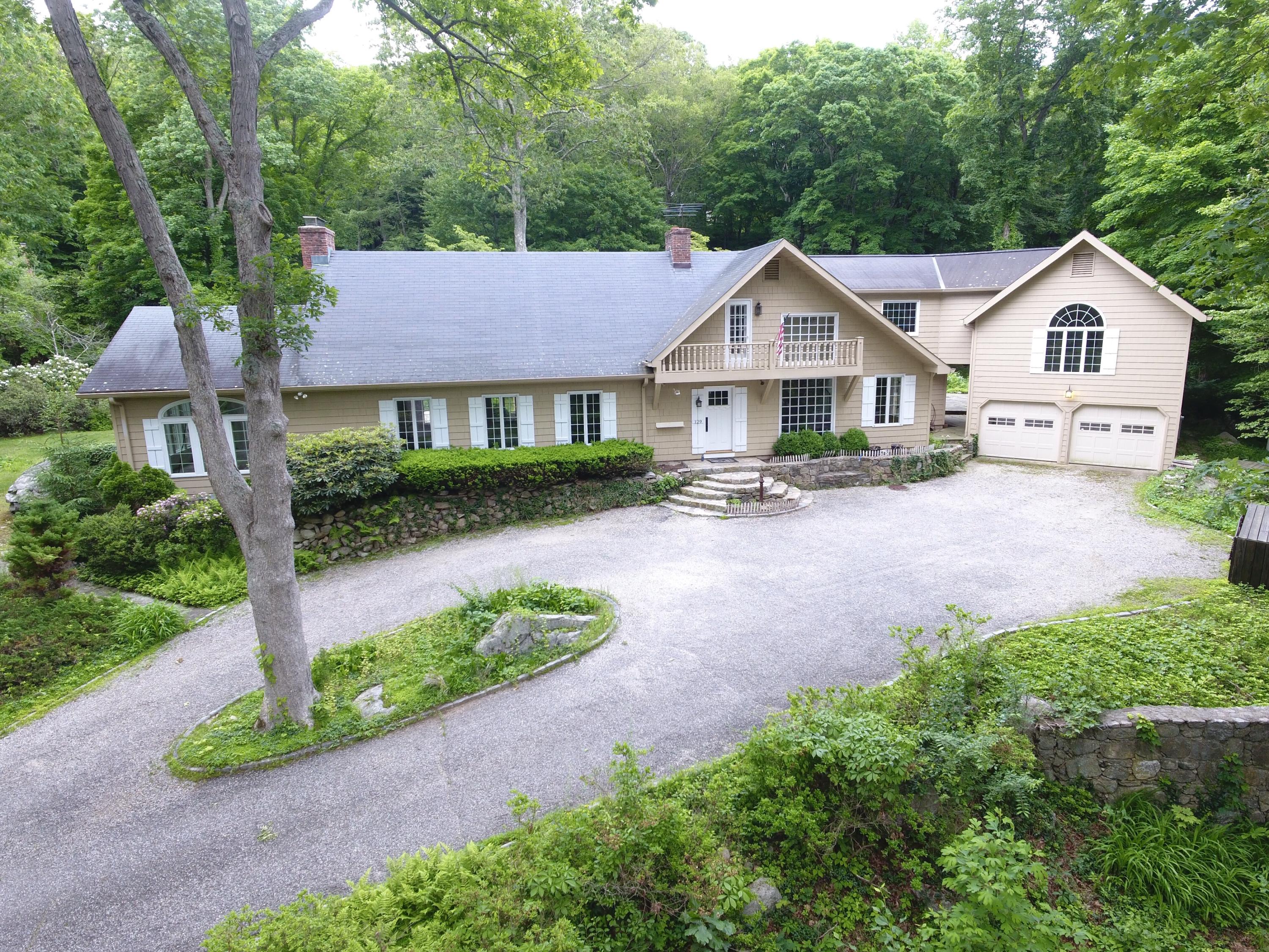 129 Hickok Road New Canaan, CT 06840 - Photo 29 of 32 a front view of a house with a yard and garage