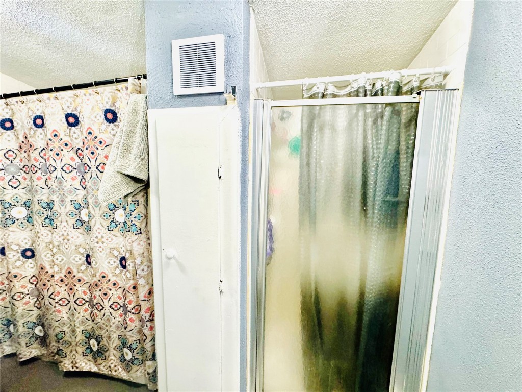 9105 Exeter Street Houston, TX 77093 - Photo 11 of 21 a bathroom with a shower and a curtain