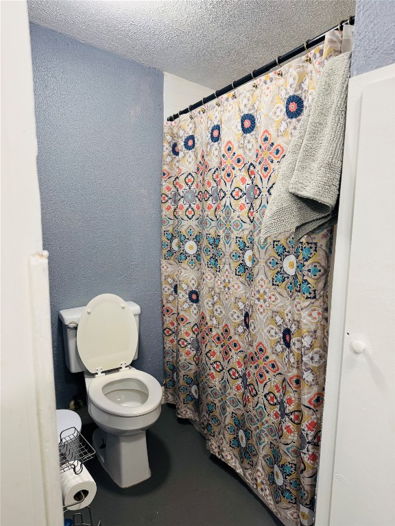 9105 Exeter Street Houston, TX 77093 - Photo 12 of 21 a white toilet sitting next to a shower curtain