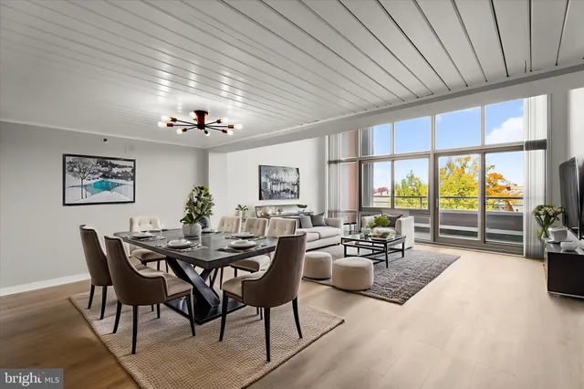 a dining room with furniture a chandelier and wooden floor