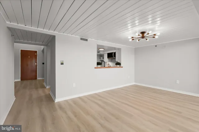 a view of a big room with wooden floor and windows
