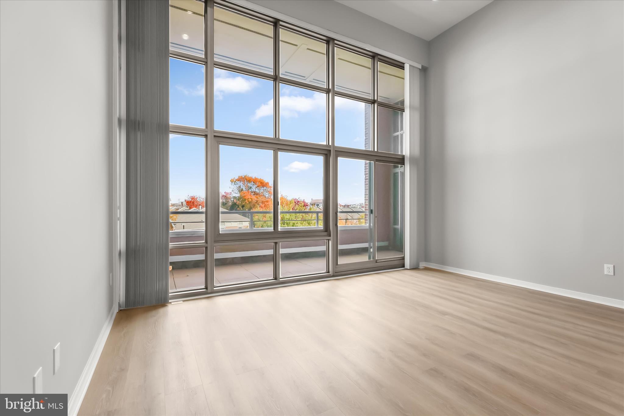 2901 Boston Street, Unit 302 Baltimore, MD 21224 - Photo 16 of 61 an empty room with wooden floor and windows