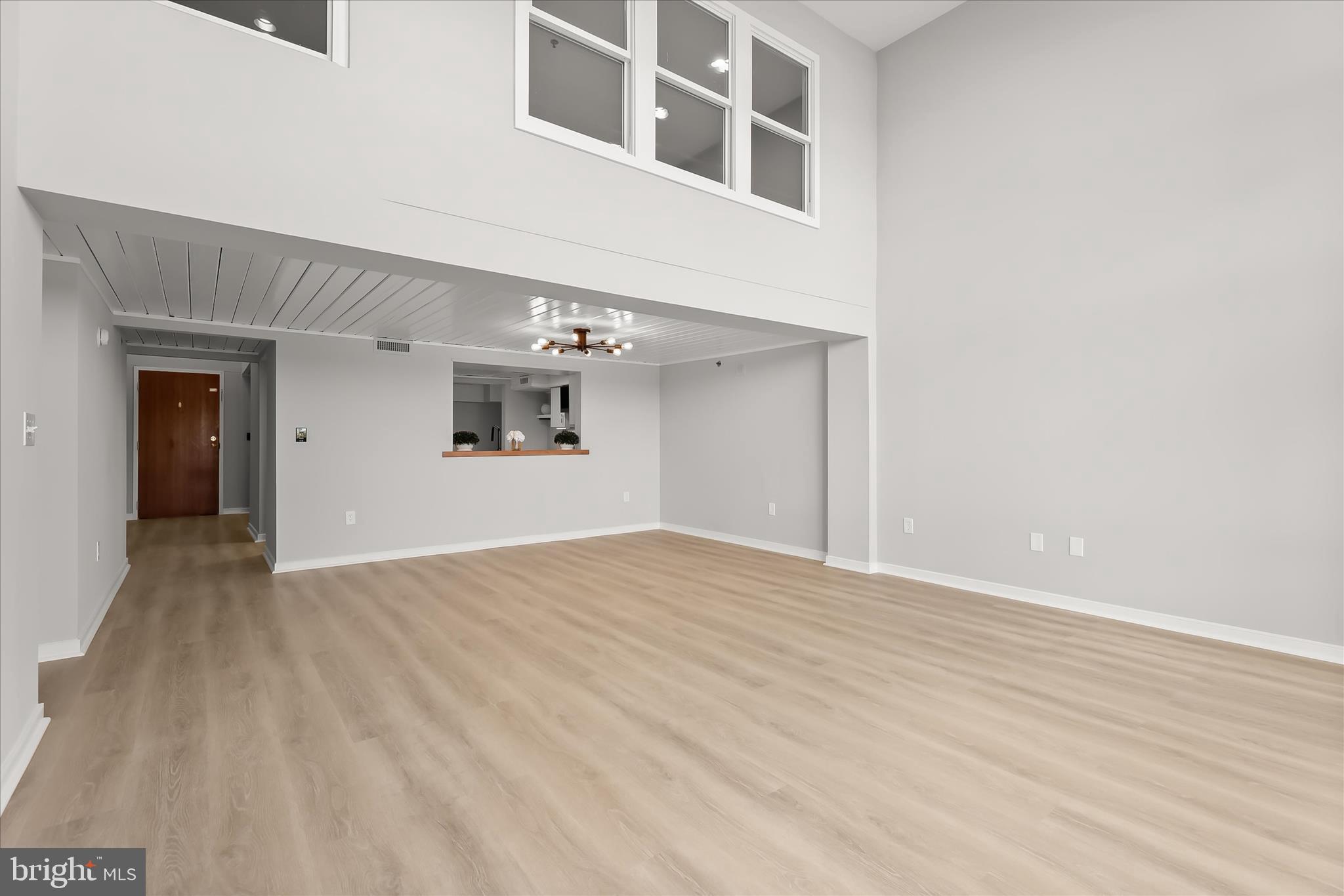 2901 Boston Street, Unit 302 Baltimore, MD 21224 - Photo 18 of 61 a view of an empty room with wooden floor and a window