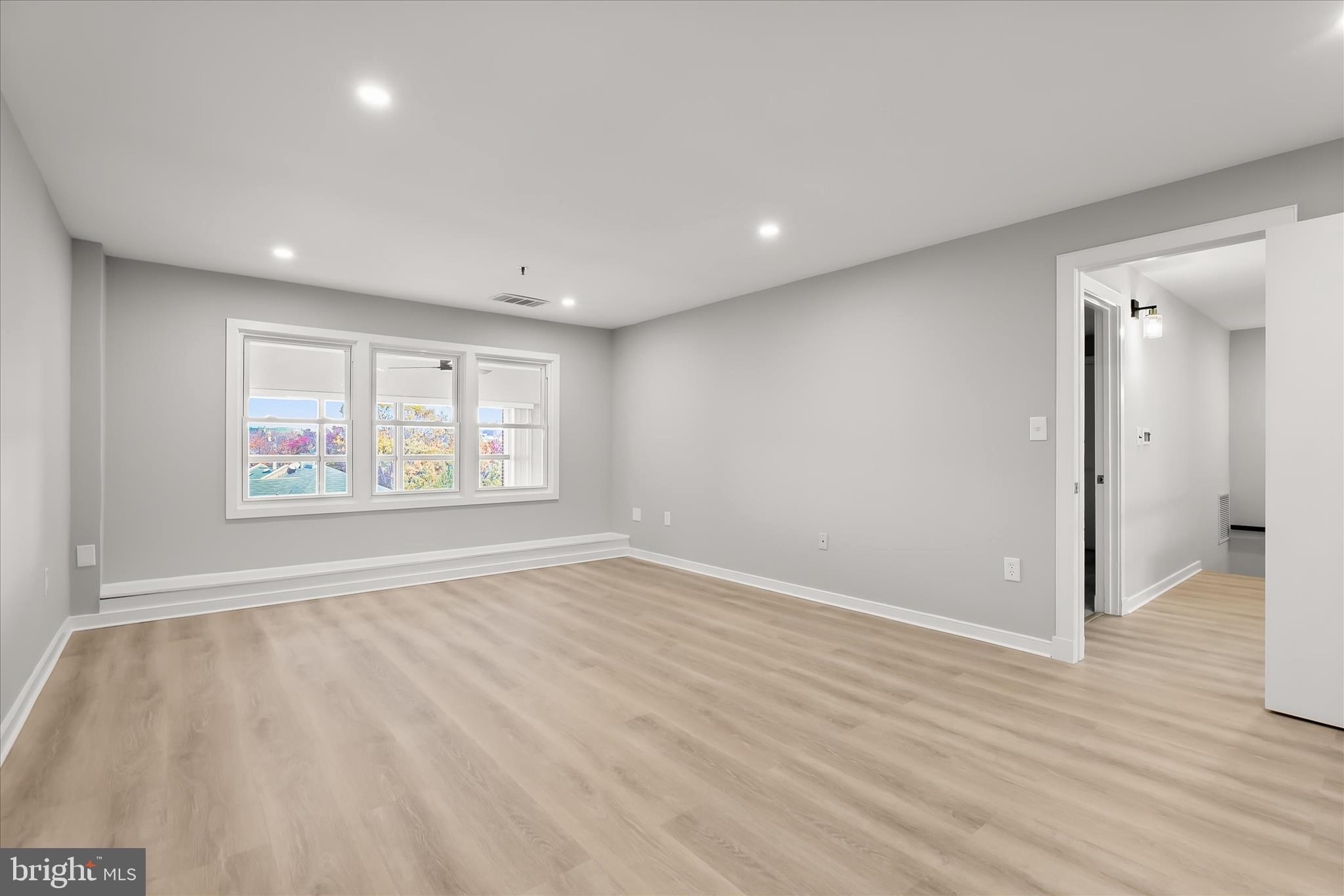 2901 Boston Street, Unit 302 Baltimore, MD 21224 - Photo 30 of 61 wooden floor in an empty room with a window