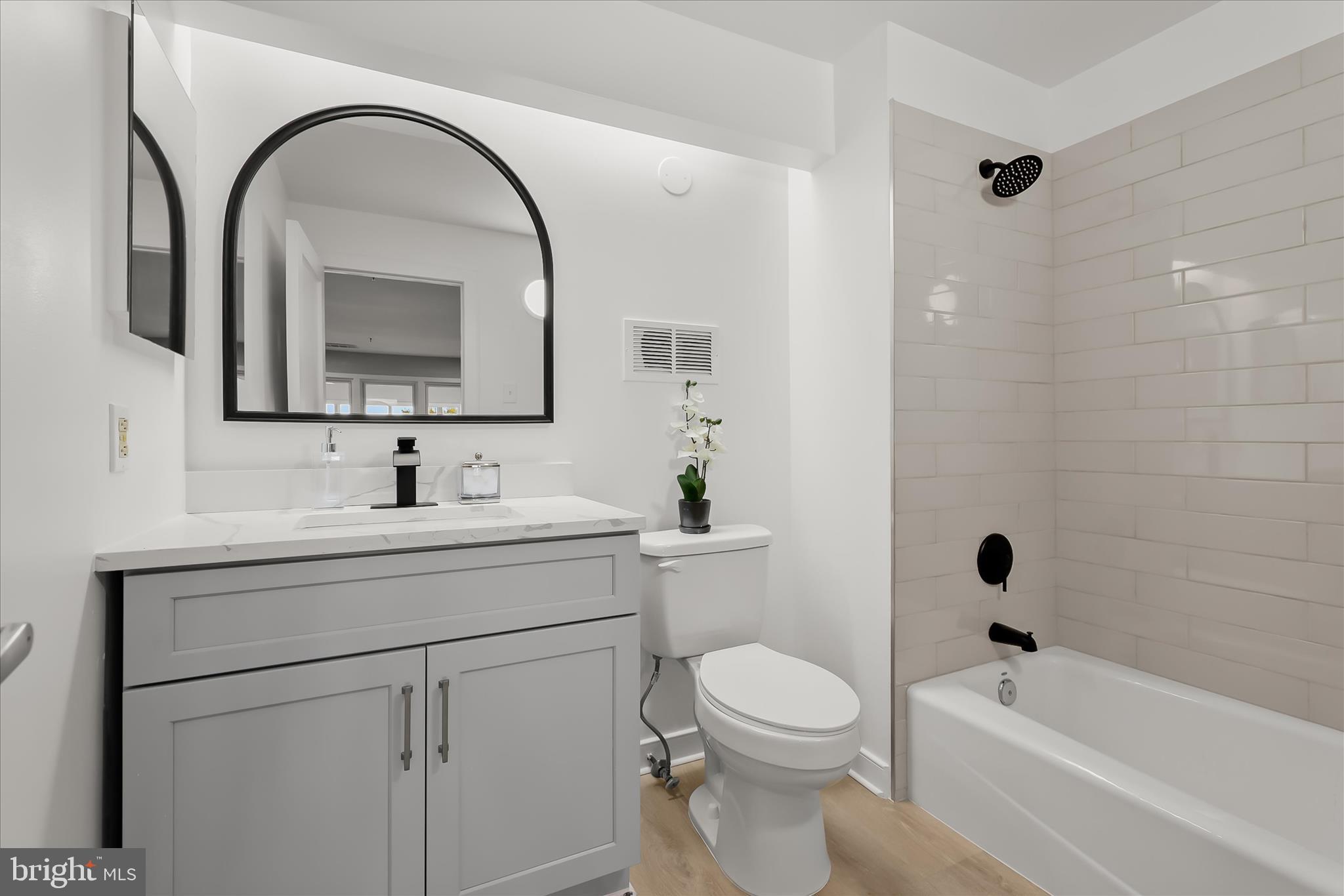 2901 Boston Street, Unit 302 Baltimore, MD 21224 - Photo 32 of 61 a bathroom with a toilet a sink a mirror and bathtub