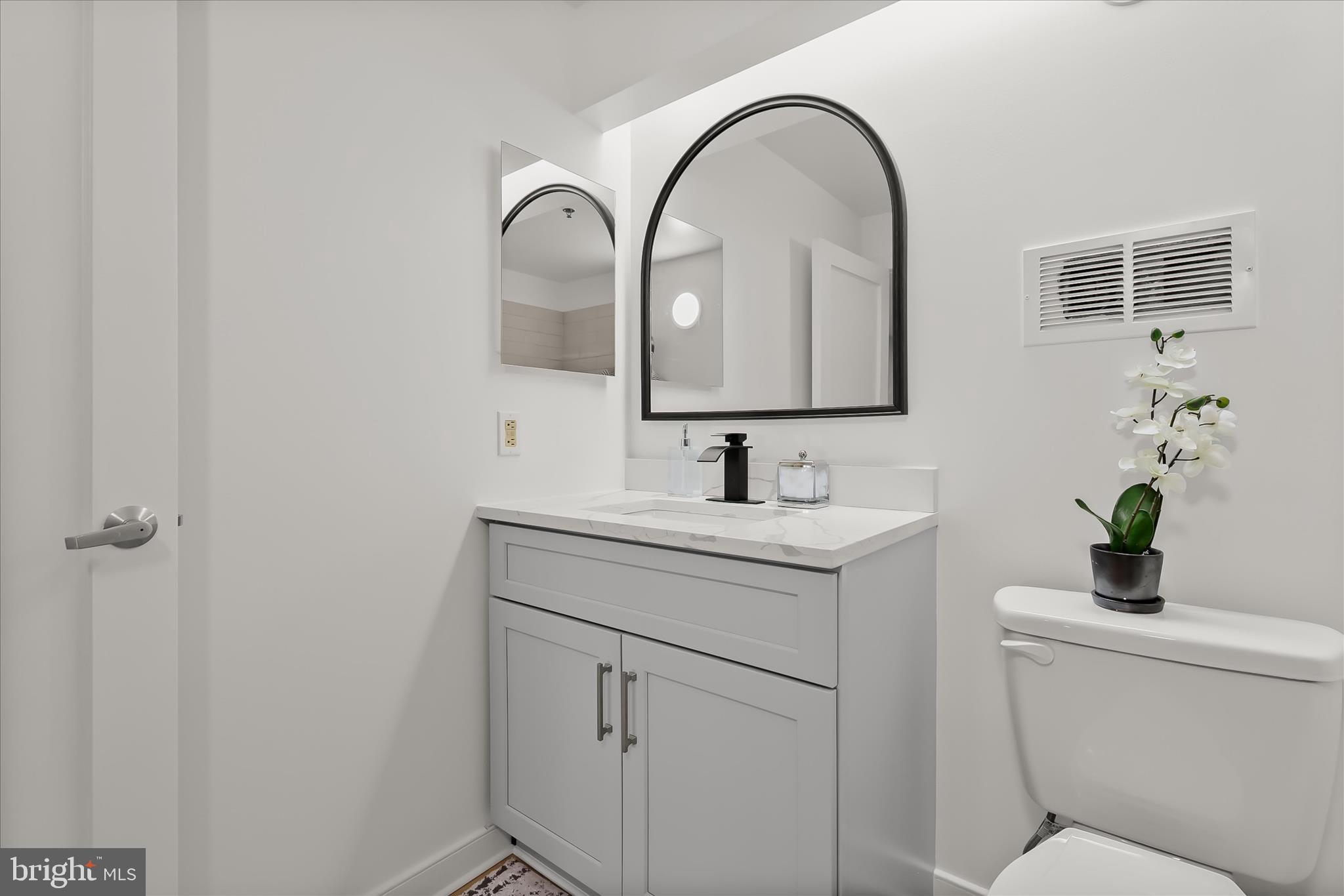 2901 Boston Street, Unit 302 Baltimore, MD 21224 - Photo 33 of 61 a bathroom with a sink toilet and a mirror