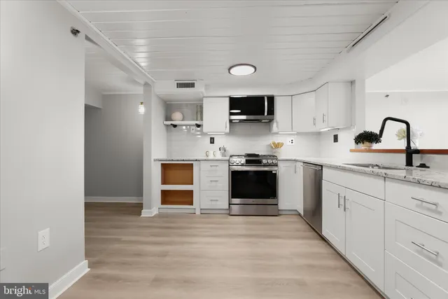 a large kitchen with stainless steel appliances granite countertop a stove and a sink